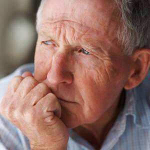 Closeup of an elderly man looking away in deep thought , depression
