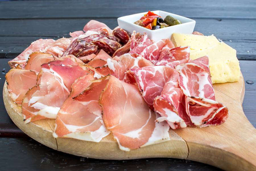 typical Italian appetizer with salami cheese and pickles in a wooden cutting board