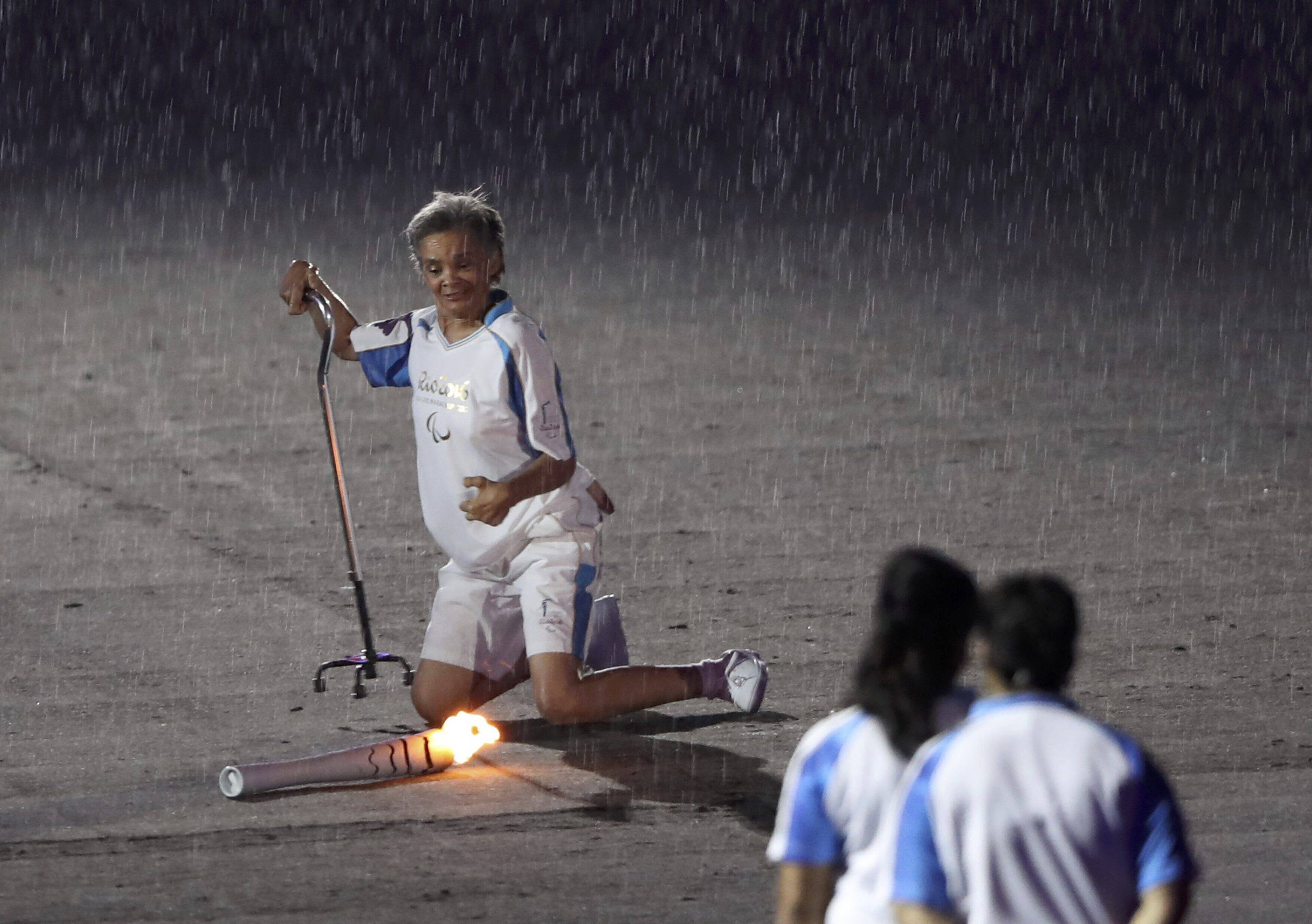 2016 Rio Paralympics - Opening ceremony - Maracana - Rio de Janeiro, Brazil - 07/09/2016. Brazilian Paralympic runner Marcia Malsar falls while carrying the torch as rain falls during the opening ceremony. REUTERS/Ueslei Marcelino FOR EDITORIAL USE ONLY. NOT FOR SALE FOR MARKETING OR ADVERTISING CAMPAIGNS.