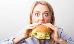 bigstock-Woman-eating-burger-120861863