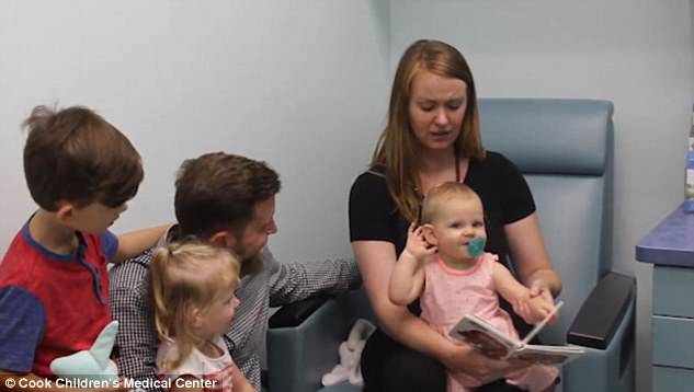 One-year-old Ayla Esler cups her ear when doctors activate her cochlear implant device
