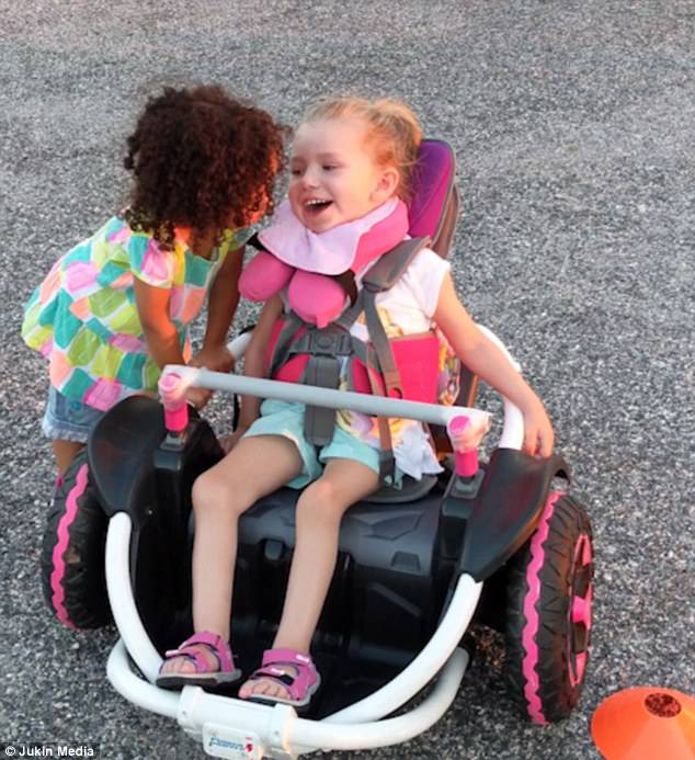 Little Abby is seen whispering some words of encouragement into her disabled friend's earÂ 