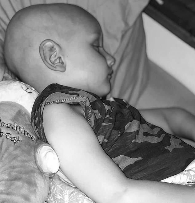 Little Charlie is pictured on October 10 in bed after losing his hair to gruelling cancer treatment
