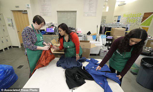 From left, Rebecca Schaechter, Nicole Herron and Rachel Herron fold and sort donated clothes at Treehouse, a nonprofit organization in Seattle,Â  that was one of several that received donations from the estate of Alan Naiman