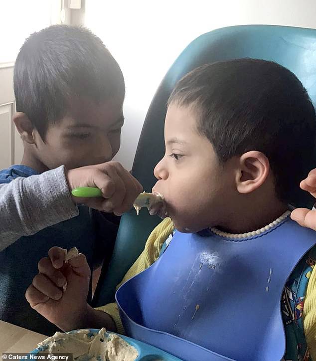 Since moving from Bulgaria last month, Simon helps his siblings eat using spoons and feeding syringes- seen feeding brother Alex,ÃÂ six, who also has Down's Syndrome